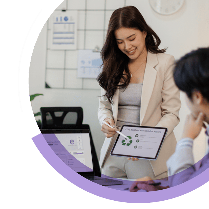 Consultant presenting sustainability metrics on a tablet during a meeting, showing ESG indicators and circular economy graphics used for sustainability reporting and strategy discussions.